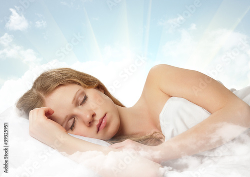 Photo: beautiful young woman sleeping on a cloud in the sky beautiful young woman sleeping on a cloud in the sky