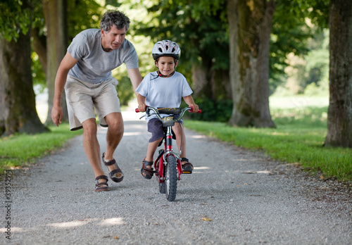 Photo: Father teaching his son to ride a bike Father teaching his son to ride a bike