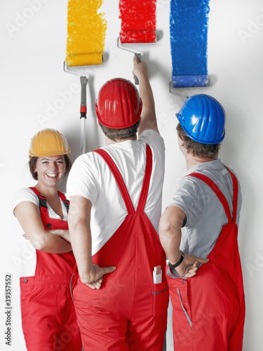 Foto: Female painter apprentice at work with two colleagues Female painter apprentice at work with two colleagues