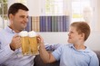 Foto: Father and son drinking beer smiling Father and son drinking beer smiling