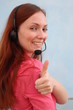 Woman with headset gesturing thumbs up