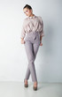 Fashion model female in light trousers and shirt standing