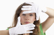 Gesicht einer jungen Frau von weißen Handschuhen umrahmt