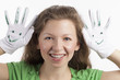 Schadenfrohe junge Dame mit Smiley Handschuhen
