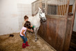 Boy and Girl Grooming a Horse