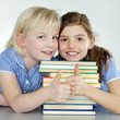 Two cute girls love reading at school and show thumps up