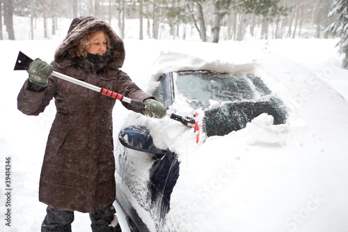 Photo: Woman removing snow from car windshield Woman removing snow from car windshield