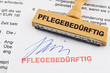 Holzstempel auf Dokument: pflegebedürftig