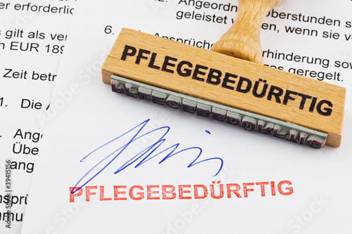 Foto: Holzstempel auf Dokument: pflegebedürftig Holzstempel auf Dokument: pflegebedürftig