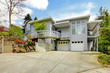Grey large modern house exterior with huge parking area.