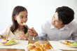 娘に朝食を食べさせる父親