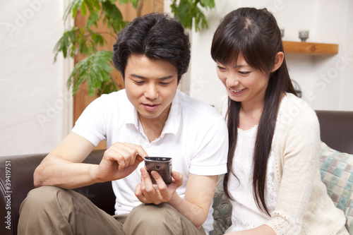 Photo: スマートフォンを見るカップル スマートフォンを見るカップル