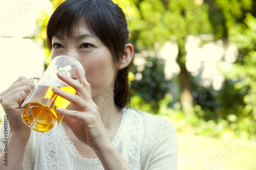 Foto: 庭でビールを飲む女性 庭でビールを飲む女性