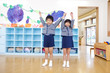 手を繋いで両手をあげる幼稚園児男女
