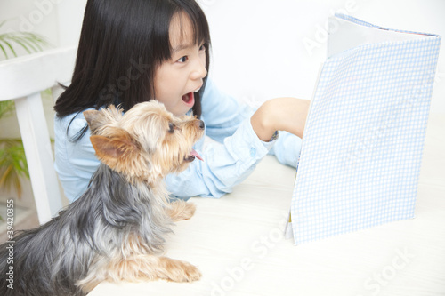 Photo: ヨークシャーテリアと本を読んで驚く女の子 ヨークシャーテリアと本を読んで驚く女の子
