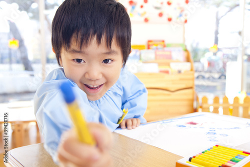 Foto: クレヨンを手に持っておどける幼稚園男児 クレヨンを手に持っておどける幼稚園男児