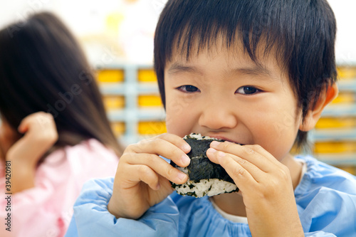 Photo: おにぎりを食べる幼稚園男児 おにぎりを食べる幼稚園男児