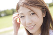 髪の毛を耳にかけながら微笑む女性