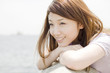 堤防で海を眺める笑顔の女性