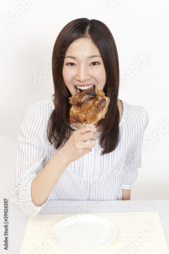 Photo: 骨付き肉を食べる女性 骨付き肉を食べる女性