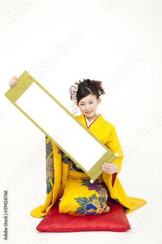 Foto: 掛け軸を持つ振袖姿の女性 掛け軸を持つ振袖姿の女性