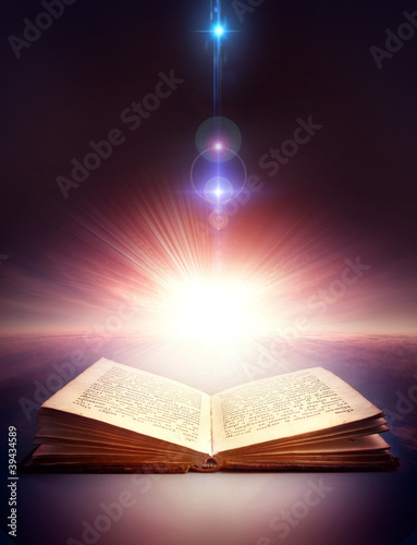 Photo: ancient open book with magic light ancient open book with magic light