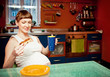 Photo: Pregnant woman with cake in kitchen Pregnant woman with cake in kitchen