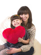 mother and her little daughter embracing with red heart