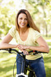 Photo: Hispanic woman in park with bike Hispanic woman in park with bike
