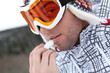 Photo: young skier putting cold cream lip stick on his lips young skier putting cold cream lip stick on his lips