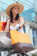 Summer in the city: woman with shopping bags and bicycle