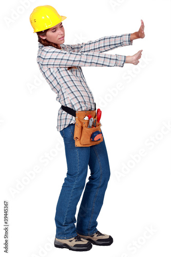 Photo: Tradeswoman pushing up against an invisible wall Tradeswoman pushing up against an invisible wall