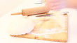 Female hands slicing dough on table. Female hands slicing dough on table.