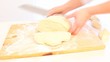 Video: Female hands slicing dough on table. Female hands slicing dough on table.