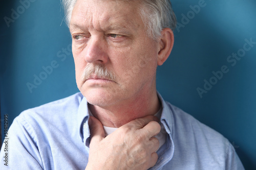 Photo: senior man with throat or neck irritation senior man with throat or neck irritation