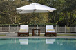 Sunbeds by a swimming pool amidst greenery at a resort