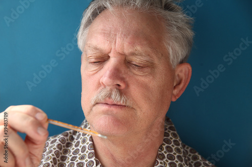 Photo: ill senior checks his fever ill senior checks his fever