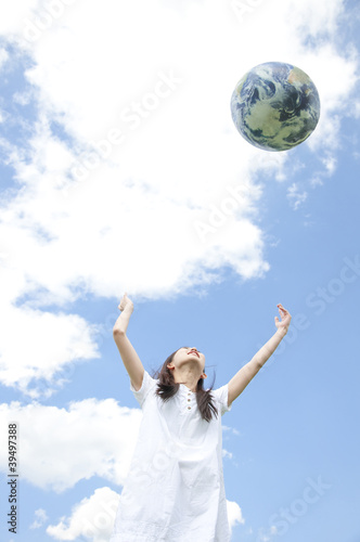 Photo: 地球儀を空に向かって投げる女性 地球儀を空に向かって投げる女性