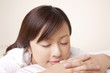 クッションを枕にして眠る女性