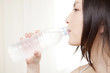 ペットボトルの水を飲む女性
