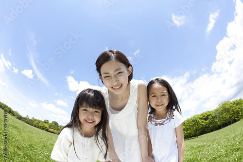 Foto: 草原で微笑む女の子2人と若い女性 草原で微笑む女の子2人と若い女性