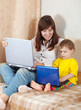 Happy woman with toddler using laptops Happy woman with toddler using laptops
