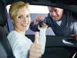 Woman in car shows thumb up, motor mechanic hands her key