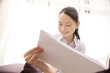 ソファーに座りばがら雑誌を読む女性