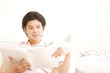 椅子に座り雑誌を読む男性