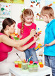 Children painting with teacher .