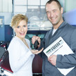 Master mechanic hands over the car key to his customer in garage