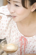 オープンカフェでデザートを食べる女性