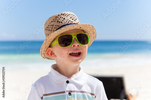 Foto: Happy boy in a straw hat on a tropical beach Happy boy in a straw hat on a tropical beach