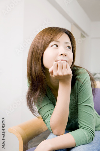 Photo: 椅子に座り頬杖をつきながら考え事をしている女性 椅子に座り頬杖をつきながら考え事をしている女性